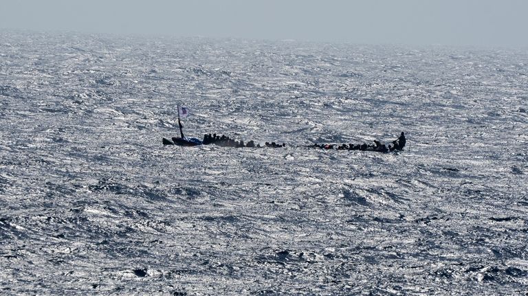 Unauthorized migrants crowd a wooden boat as they sail to...