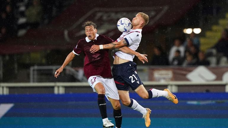 Torino's Mergim Vojvoda, left, and Bologna's Jens Odgaard battle for...