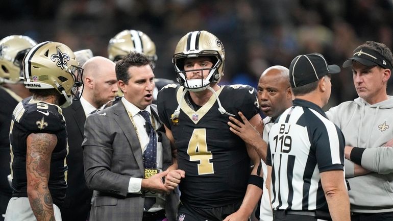 New Orleans Saints quarterback Derek Carr (4) is helped off...