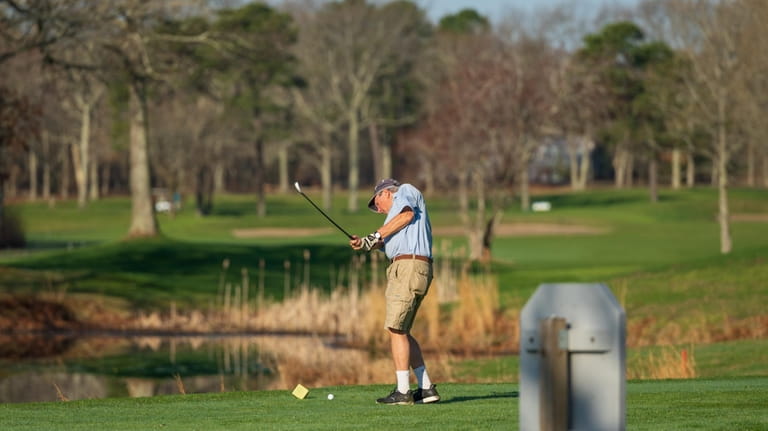 David Rung, of Southampton, takes a practice swing at Swan Lake Golf...