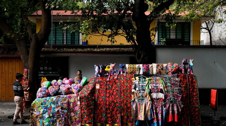 A car covered with handicrafts for sale is parked on...