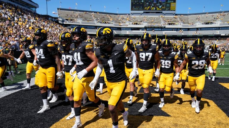 Iowa defensive back Xavier Nwankpa (1) leads his team off...