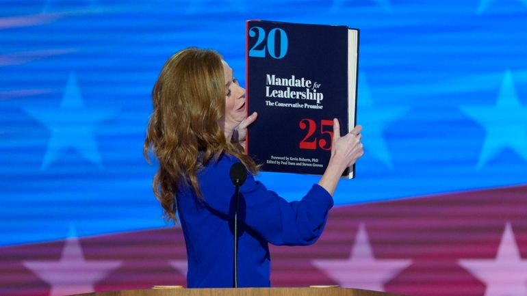 Michigan State Senator Mallory McMorrow holding up a book during...