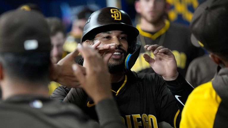 San Diego Padres' Fernando Tatis Jr. is congratulated by teammates...