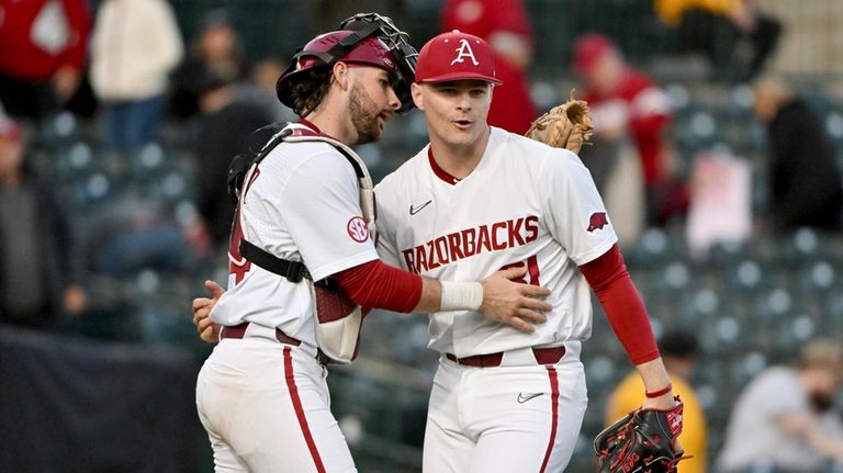 Arkansas catcher Parker Rowlan, left, and pitcher Dylan Carter, right,...