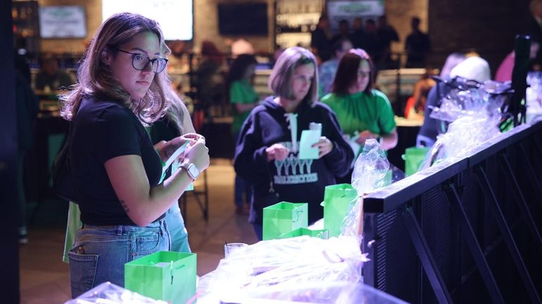 Former Farmingdale High School marching band member Kyla Koch, left, at Wednesday's fundraiser...