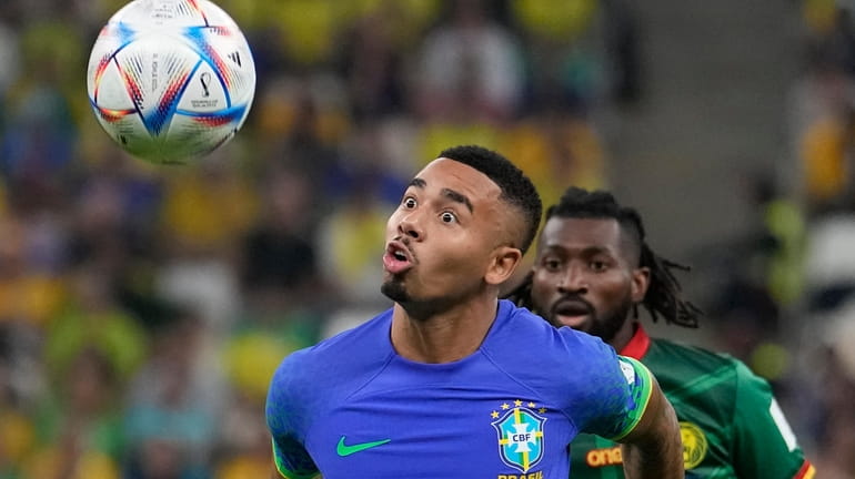 Brazil's Gabriel Jesus, front, and Cameroon's Andre-Frank Zambo Anguissa, behind,...