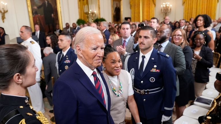 President Joe Biden walks with Dawn Staley, Coach of the...