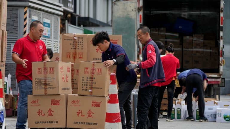 Workers load and pack gift boxes for the upcoming Mid-Autumn...