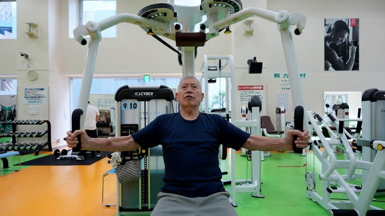 Shigeo Takahashi, 83, uses a pec deck machine as he...