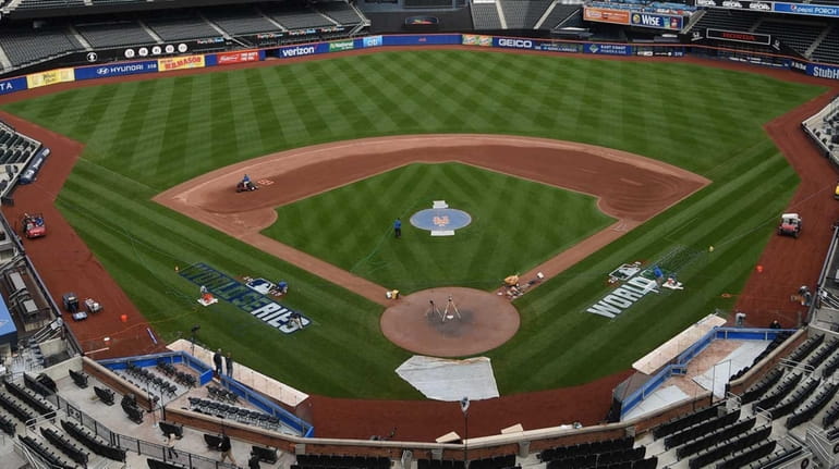 Members of the grounds crew paint the World Series logo on