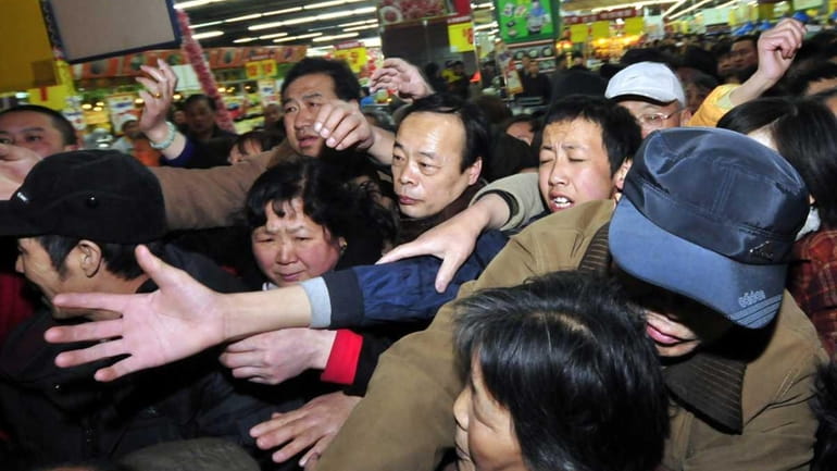 Shoppers mob a supermarket Thursday to purchase salt in Lanzhou,...