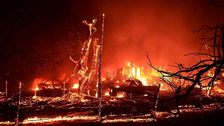 A home burns during the Corral Fire at Bernard and...