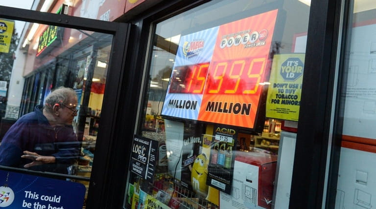 A Powerball sign reads $999 million dollars in the window...