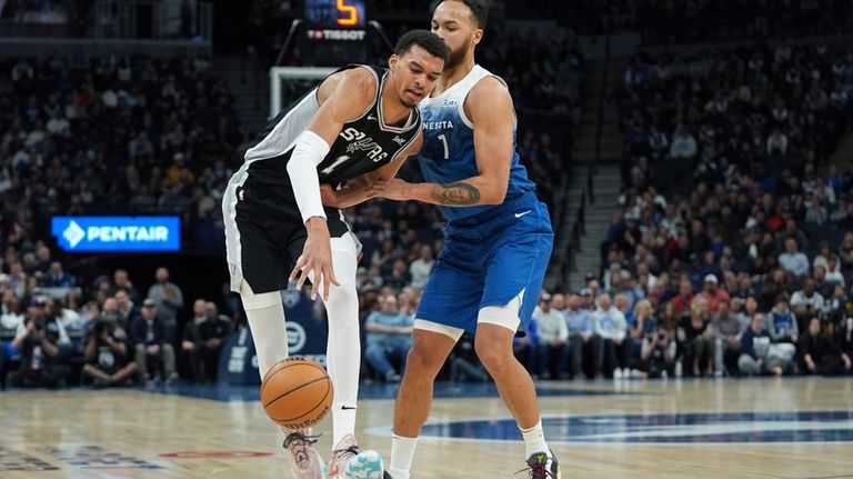 San Antonio Spurs center Victor Wembanyama, left, works toward the...