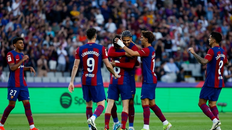 Barcelona's Pedri, center, is congratulated after scoring his side's 3rd...