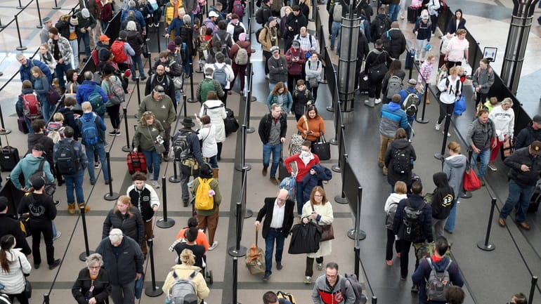 Passengers wait in a security line at Denver International Airport...