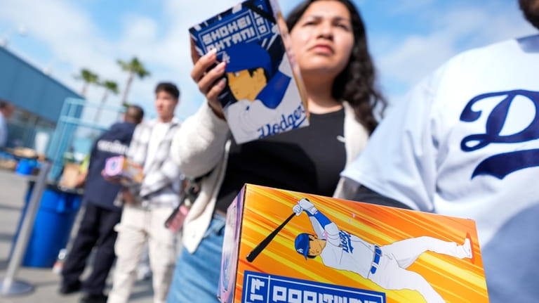 Fans carry bobbleheads of Los Angeles Dodgers designated hitter Shohei...