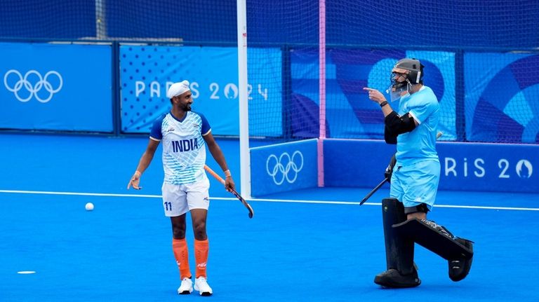 New Zealand's goalkeeper Dominic Dixon, right, gestures as India's Mandeep...