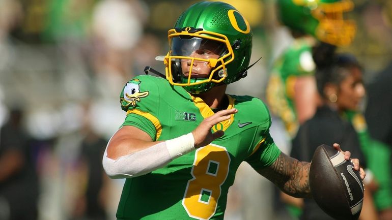 Oregon quarterback Dillon Gabriel warms up before an NCAA college...