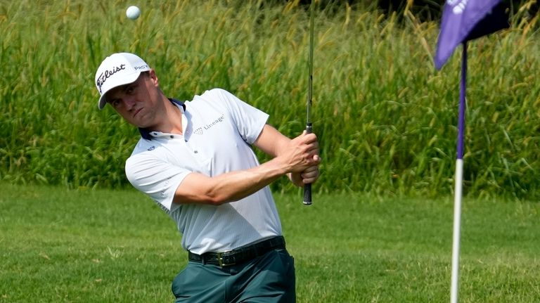 Justin Thomas chips onto the sixth green during the first...