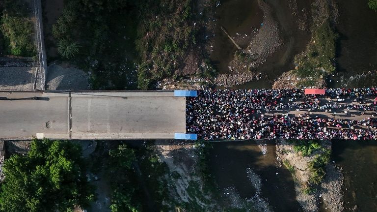 People wait in Ouanaminthe, Haiti to cross into Dajabon, Dominican...