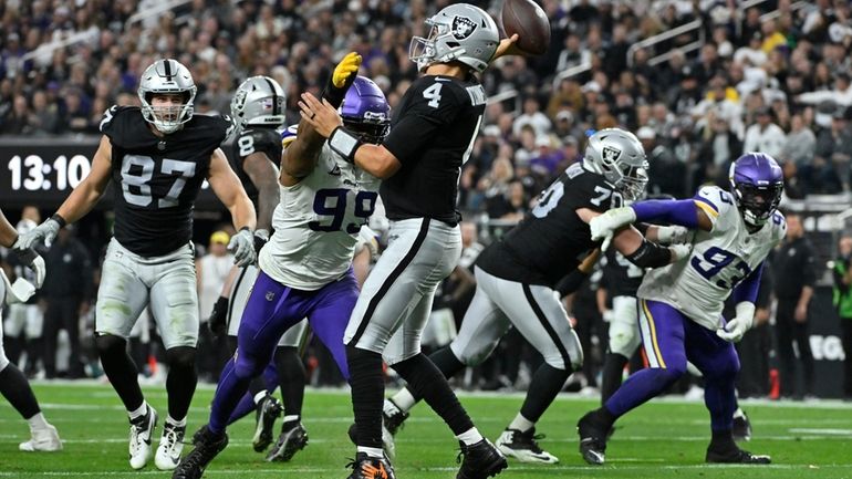 Las Vegas Raiders quarterback Aidan O'Connell (4) is pressured by...