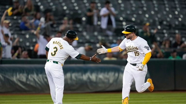 Oakland Athletics' Seth Brown, right, celebrates with third base coach...