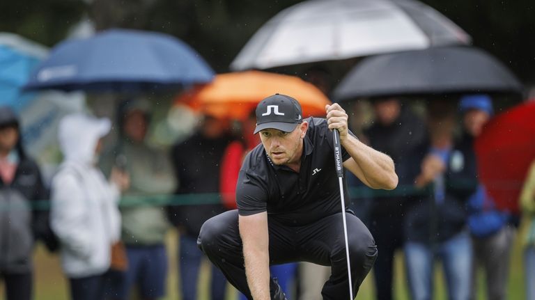 Matt Wallace lines up his putt during the fourth and...