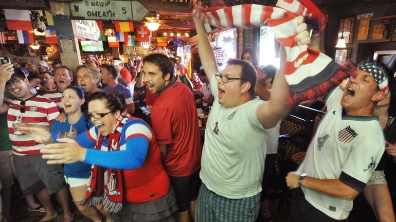 Soccer fans cheer before the World Cup match between the...