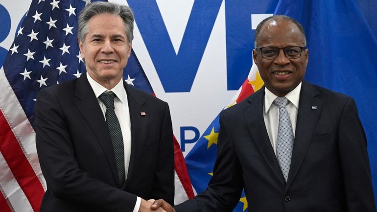 US Secretary of State Antony Blinken, left, shakes hands with...