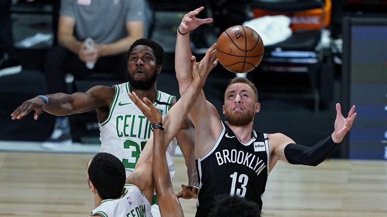 Dzanan Musa #13 of the Brooklyn Nets grabs a rebound...