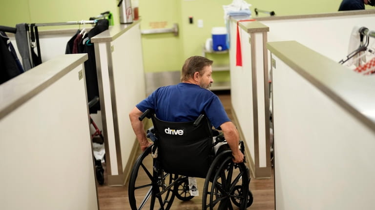 Ron Falk, 62, uses his wheelchair to navigate the corridors...