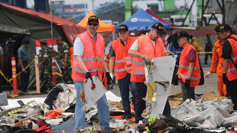 U.S. investigators examine parts recovered from the crash of a...