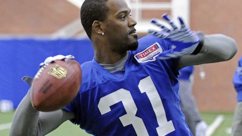 Giants cornerback Aaron Ross throws a pass during football practice....