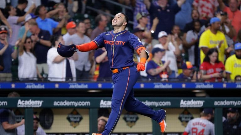 Houston Astros' Yainer Diaz throws his helmet up as he...