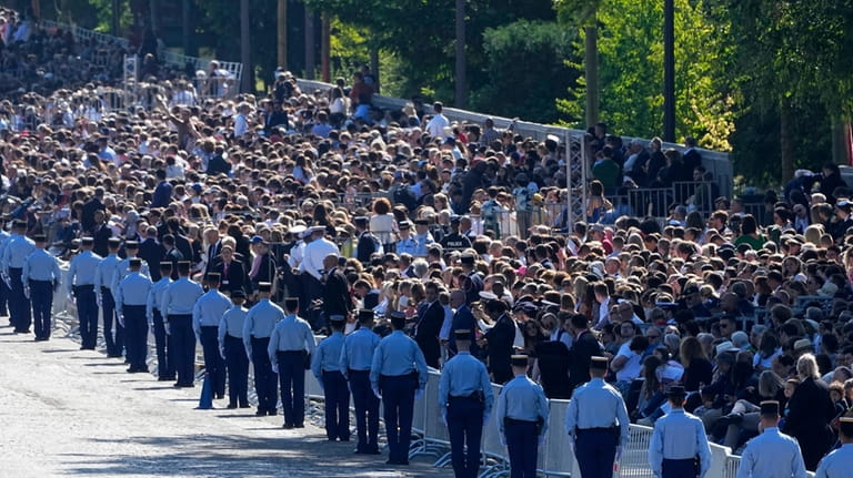 Police officers line up by the public before the Bastille...