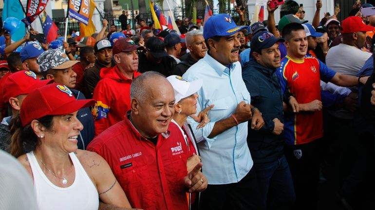 Venezuelan President Nicolas Maduro, center, accompanied by lawmaker Diosdado Cabello,...