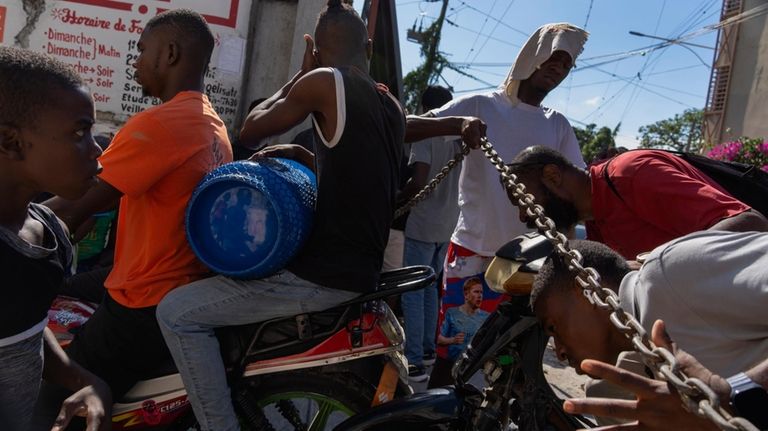 A man lifts a chain being used as a barricade...