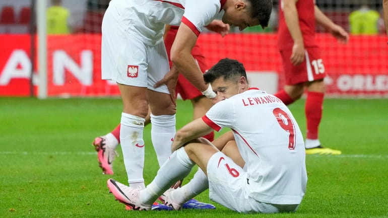 Poland's Robert Lewandowski, bottom, reacts during the international friendly soccer...