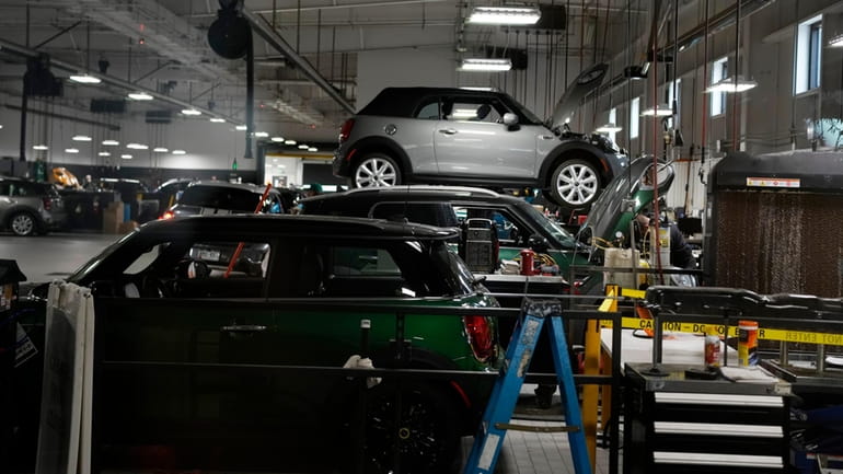 Cooper models are tended to in the service bay of...