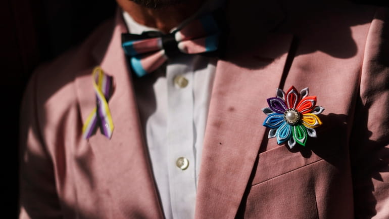 A rainbow flower sits in the jacket pocket of Scout,...