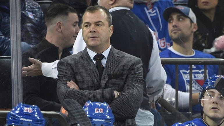 Alain Vigneault watches game action in the second period between...