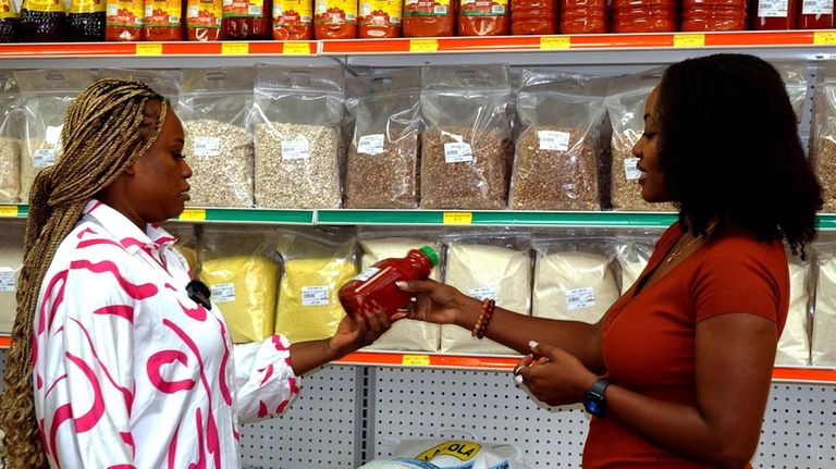 Amina Iduma, of West Hempstead, right, owner of Lami African...