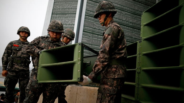 South Korean soldiers dismantle loudspeakers that set up for propaganda...
