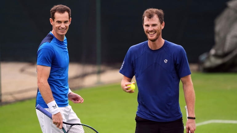 Andy Murray, left, and Jamie Murray stand on the practise...