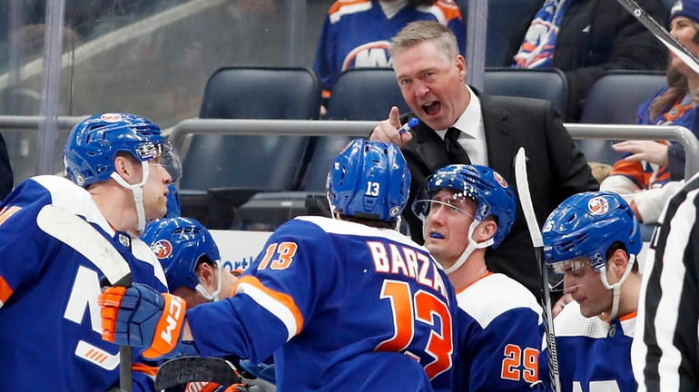 Islanders head coach Patrick Roy talks with his players during the...