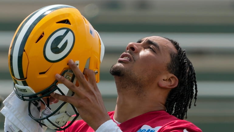 Green Bay Packers' Jordan Love puts on his helmet during...