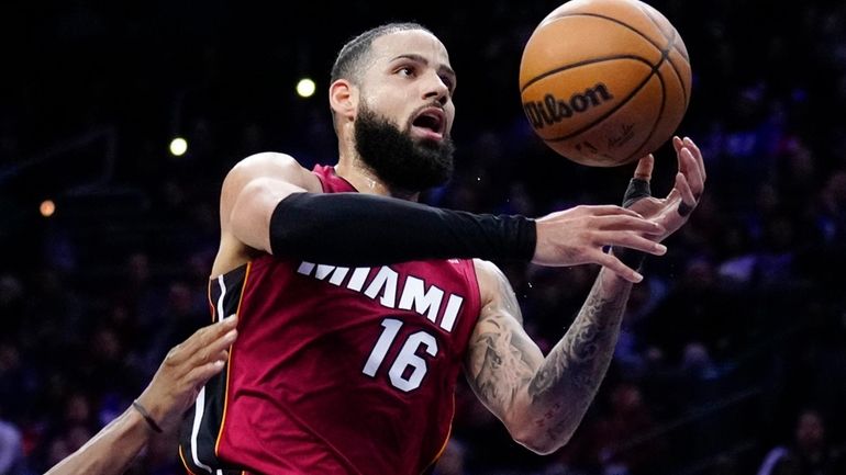 Miami Heat's Caleb Martin (16) goes up for a shot...