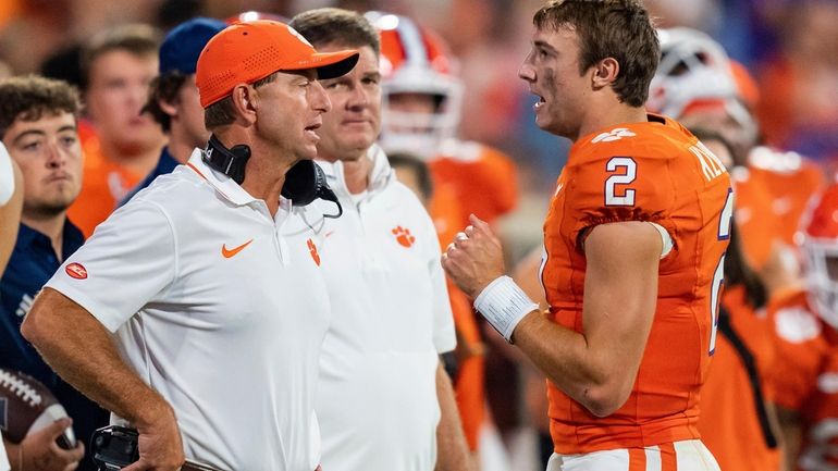 Clemson head coach Dabo Swinney, front left, talks with quarterback...